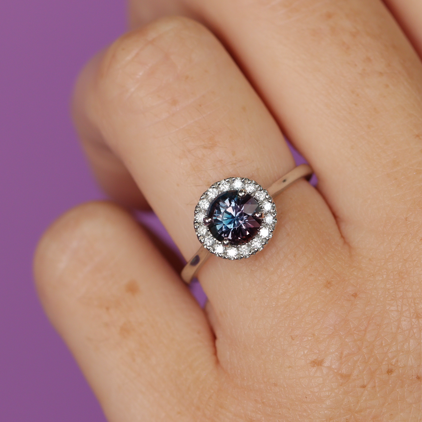 Round cut sapphire engagement ring with white diamond halo in platinum