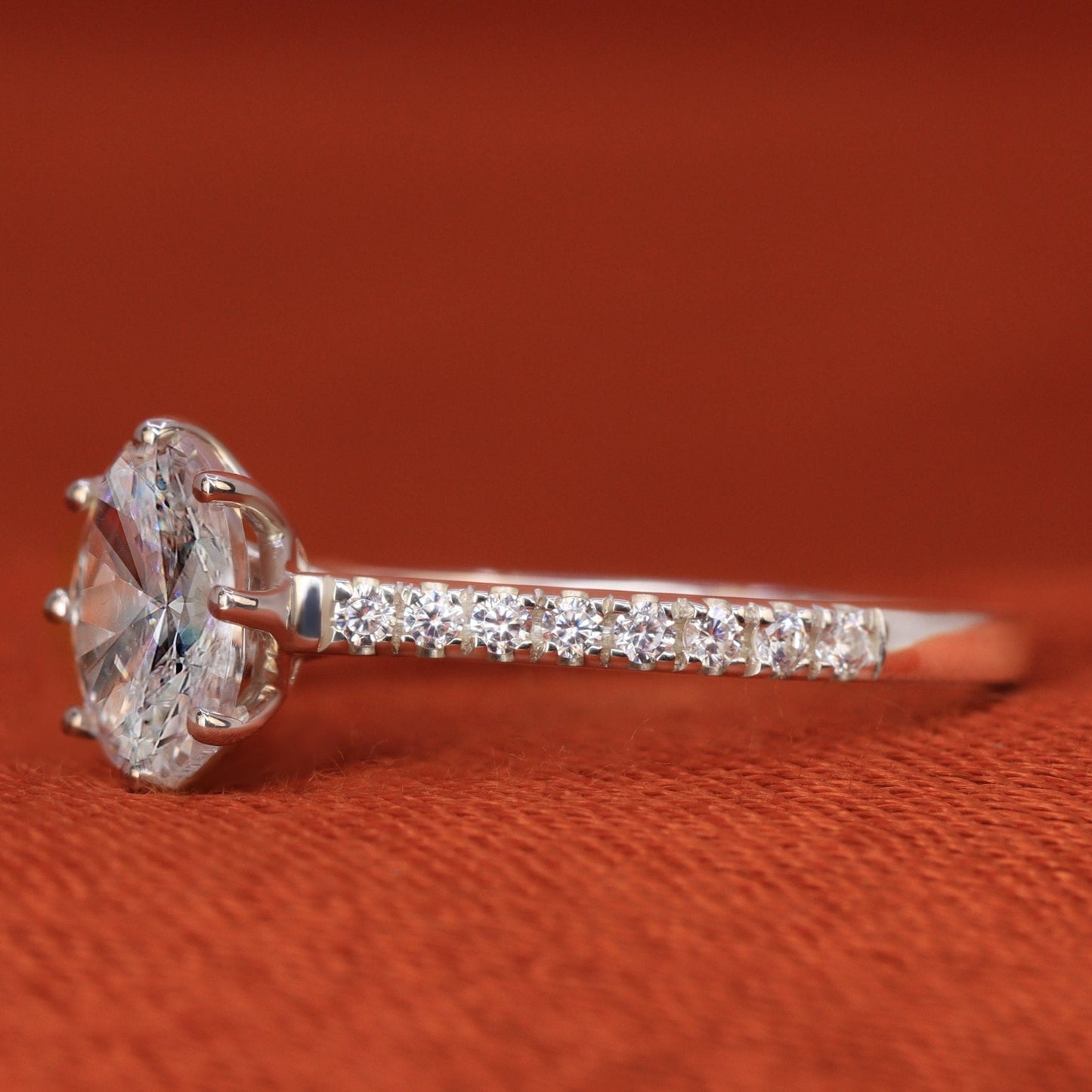 Oval lab grown diamond solitaire engagement ring with diamond pave band