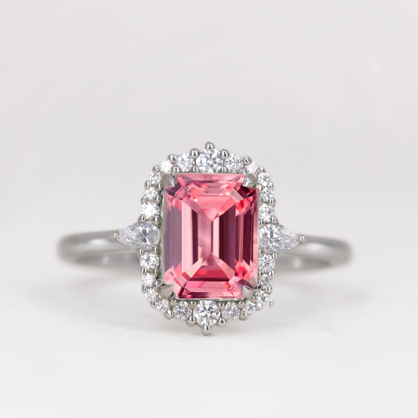 Emerald cut pink sapphire platinum engagement ring with diamond halo