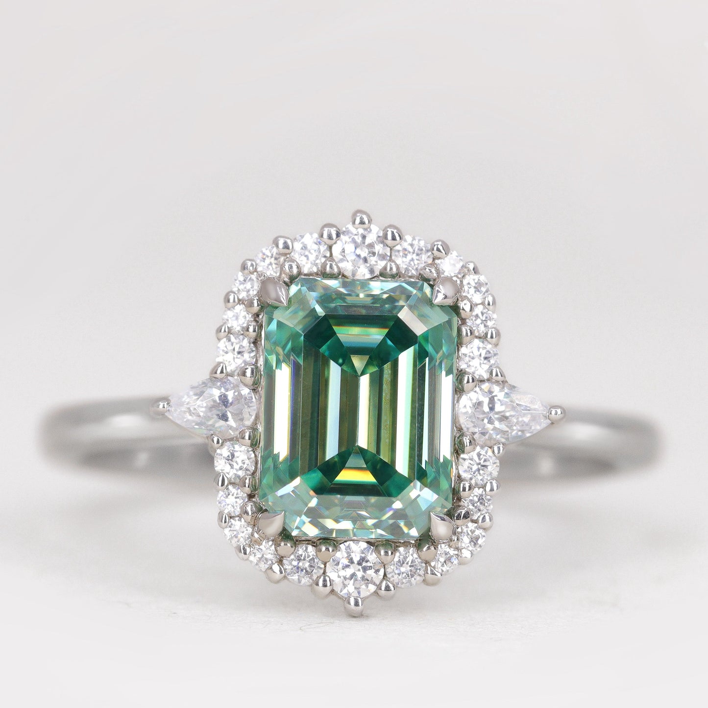 Emerald cut teal moissanite platinum engagement ring with diamond halo