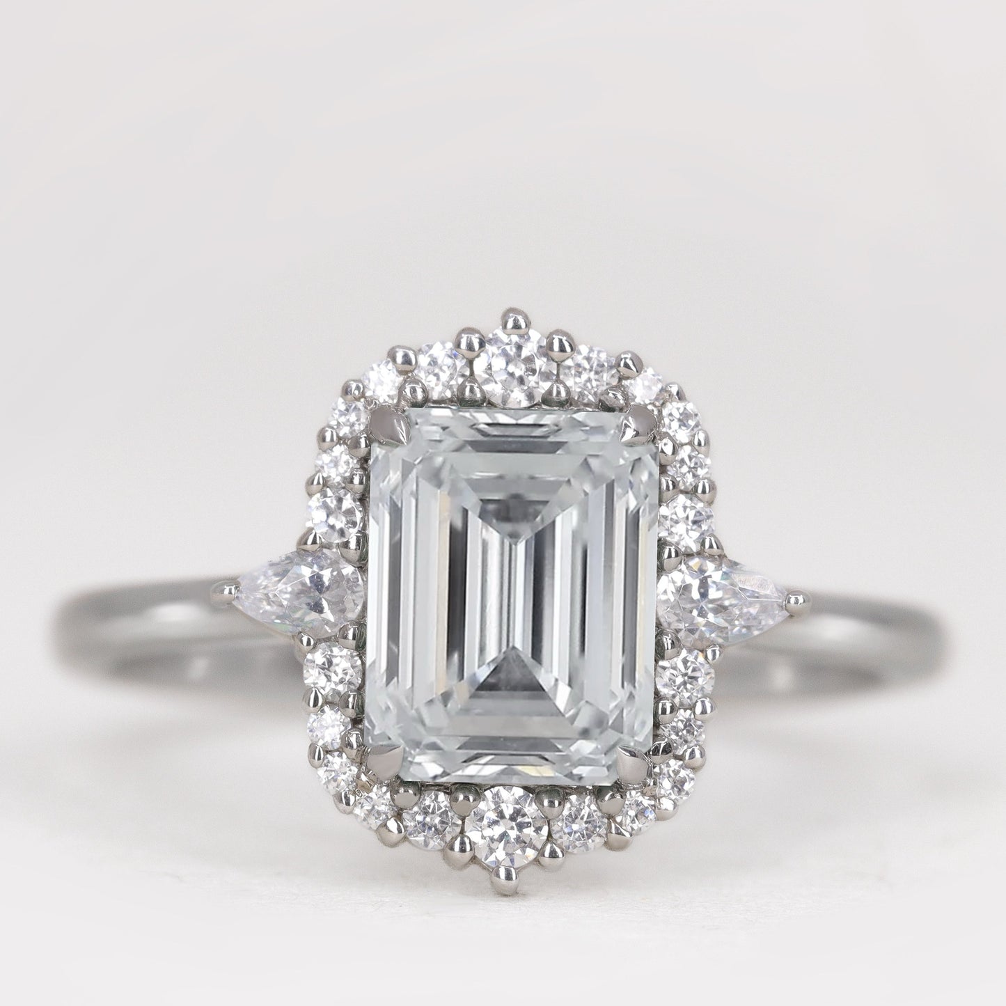 Emerald cut white diamond with diamond halo engagement ring in platinum
