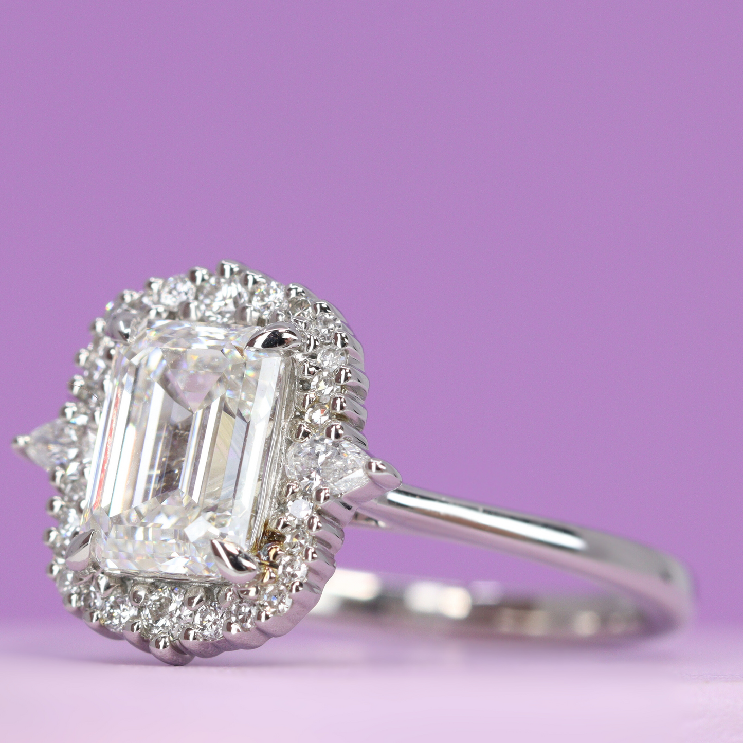 Emerald cut white diamond with diamond halo engagement ring in platinum
